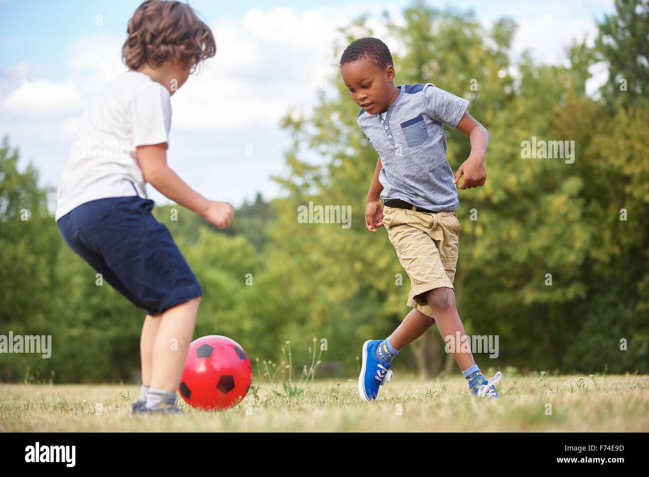 Deux enfants jouent au soccer à l'été Banque D'Images