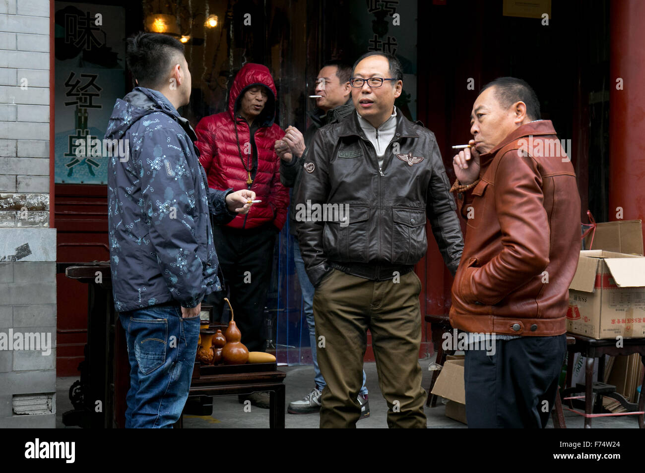 Hommes parler et fumer des cigarettes au marché antique de Beijing Banque D'Images
