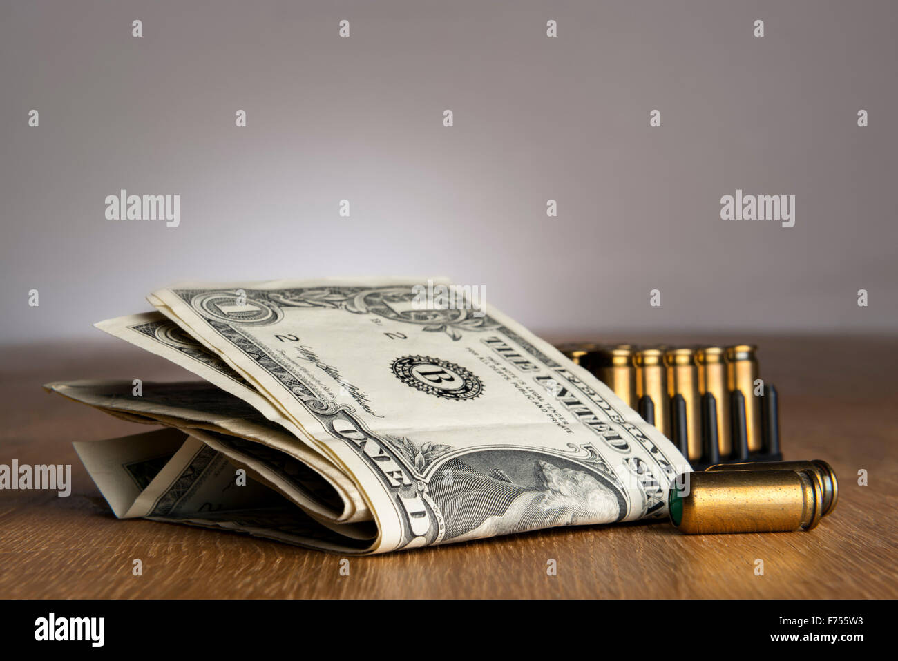 Image de dollar bills de pistolets cartouches sur une table Banque D'Images