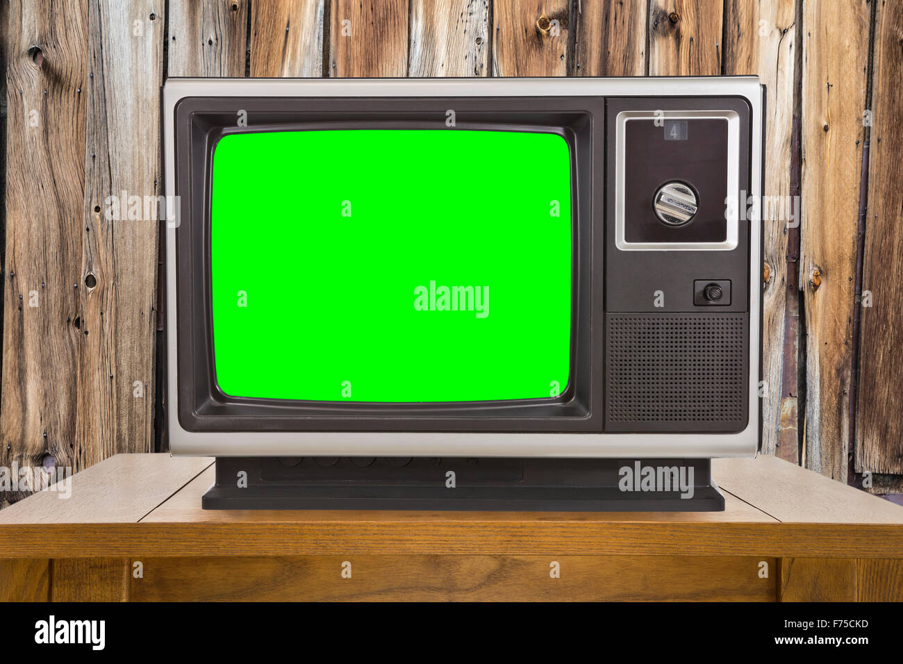 L'ancien téléviseur avec écran vert chroma key et mur en bois rustique. Banque D'Images