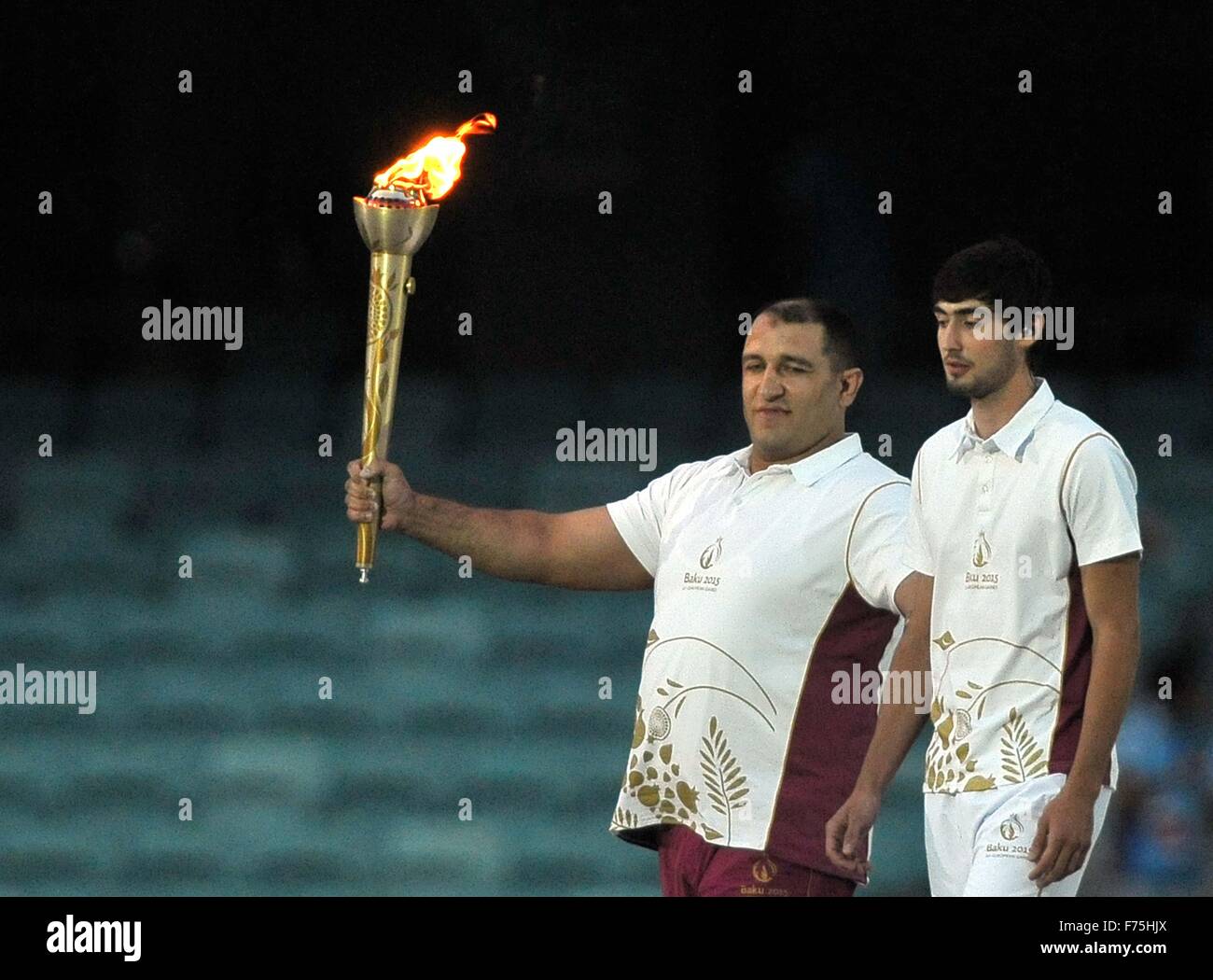 La flamme arrive dans le stade. Porté par porteur de flambeau final Ilham Zakiyev accompianed par dit Guliyev. Cérémonie d'ouverture. Stade olympique. Bakou. L'Azerbaïdjan. Baku2015. 1er jeux européens. Le 12/06/2015. Banque D'Images