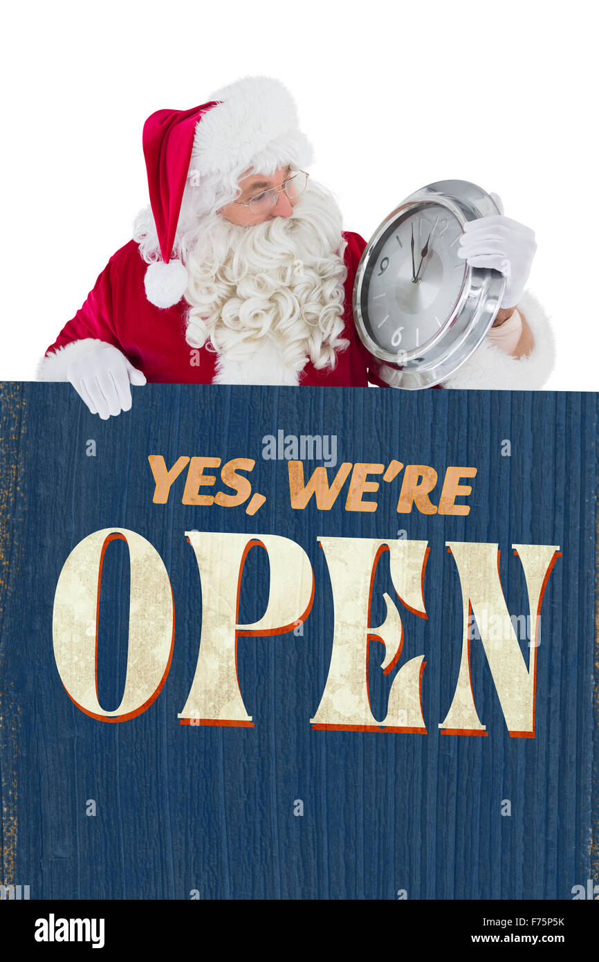 Image composite de santa avec un réveil et signer Banque D'Images