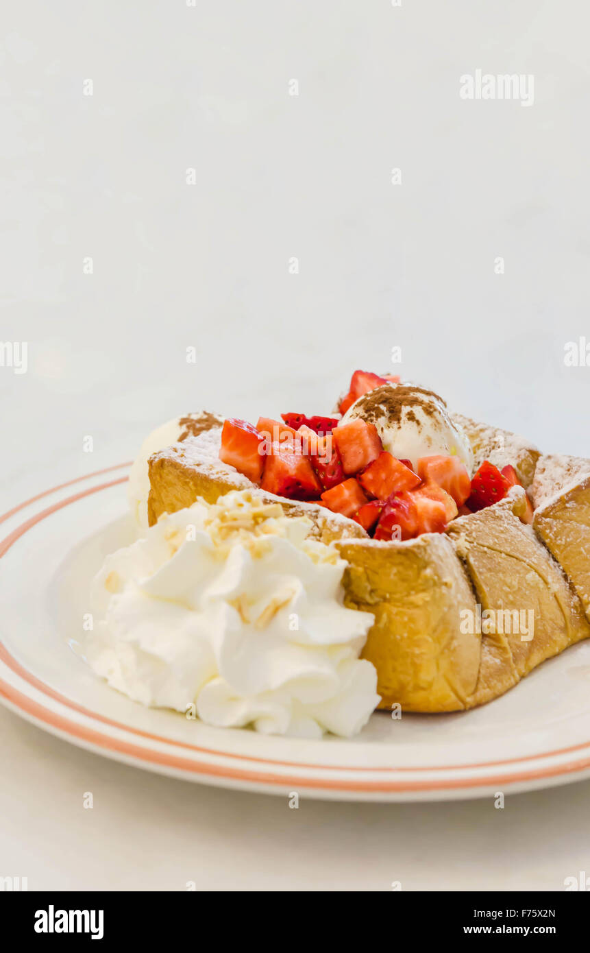 Toast au miel fraises avec de la crème glacée et la crème fouettée Banque D'Images