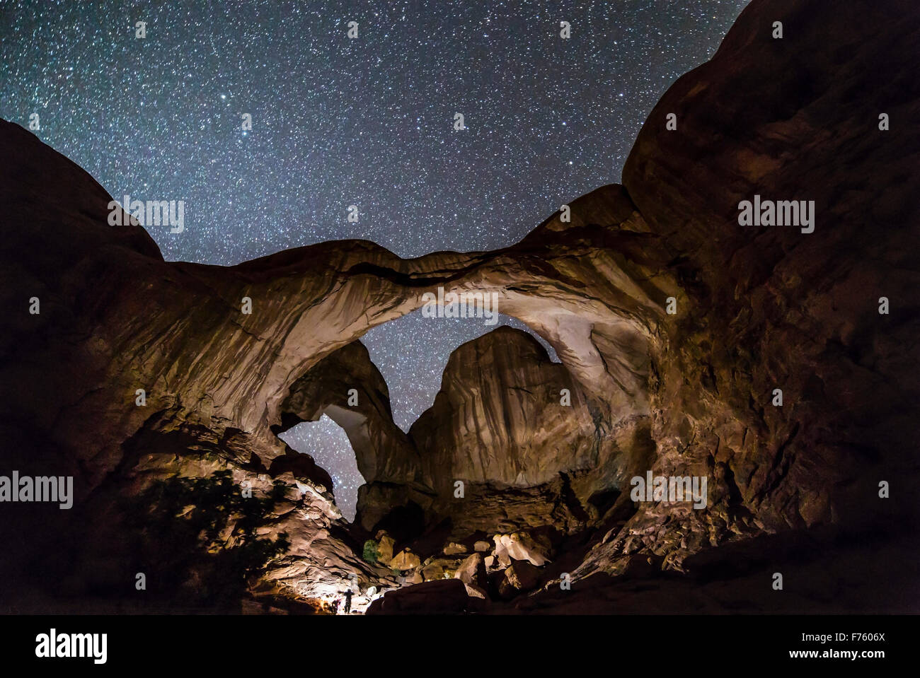 Un photographe à l'aide d'un voyant lumineux dans l'Arcade Double Arches National Park, Utah, sur une nuit sombre avant de lever de la pro Banque D'Images