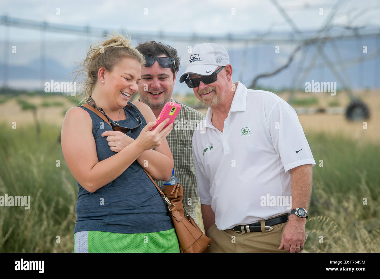 Des gens rire en regardant un téléphone intelligent dans une ferme en Afrique du Sud Banque D'Images