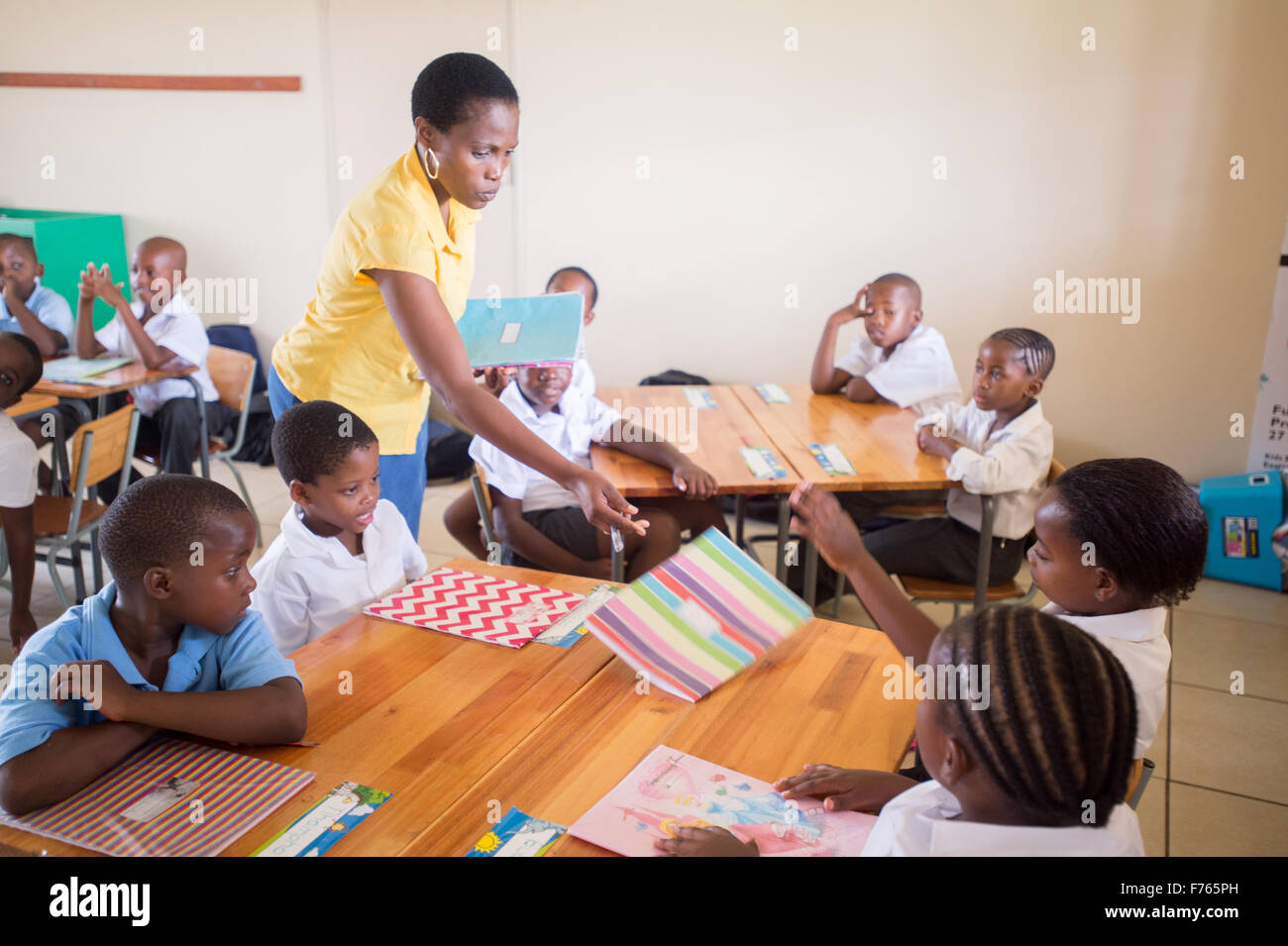 Afrique du Sud - Enseignant distribuant des dossiers de classe. Banque D'Images