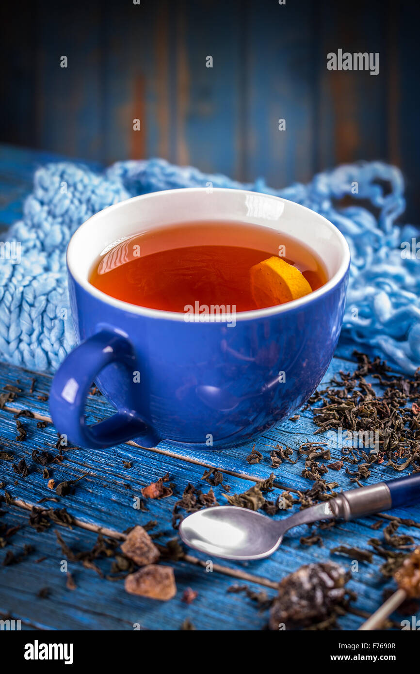 Tasse de thé noir avec bleu sur bleu surface en bois Banque D'Images