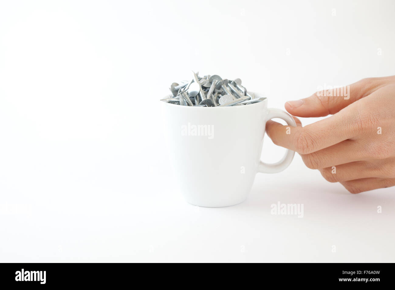 Femme ramasse une tasse à café de clous Banque D'Images