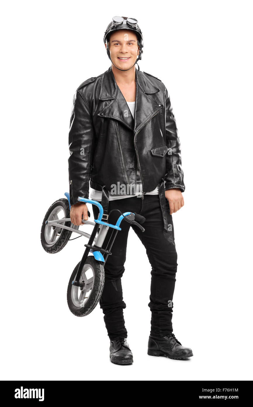 Portrait d'un jeune motocycliste tenant un petit vélo d'enfant et à la recherche à l'appareil photo Banque D'Images