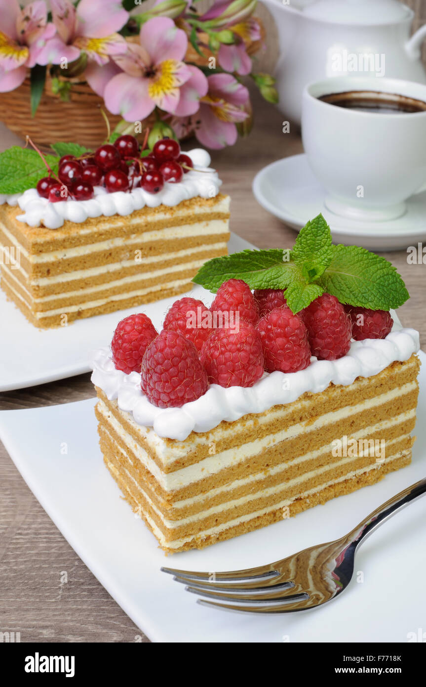 Morceau de gâteau au miel avec de la crème fouettée et de framboises Banque D'Images