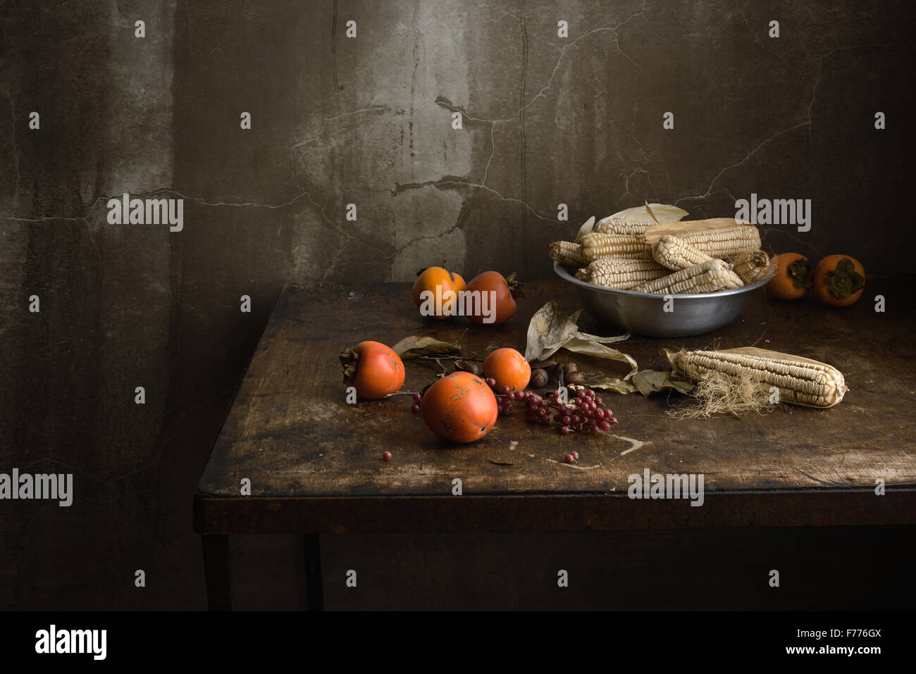 Nature morte avec fruits et de maïs dans un bol d'aluminium sur une vieille table en bois Banque D'Images