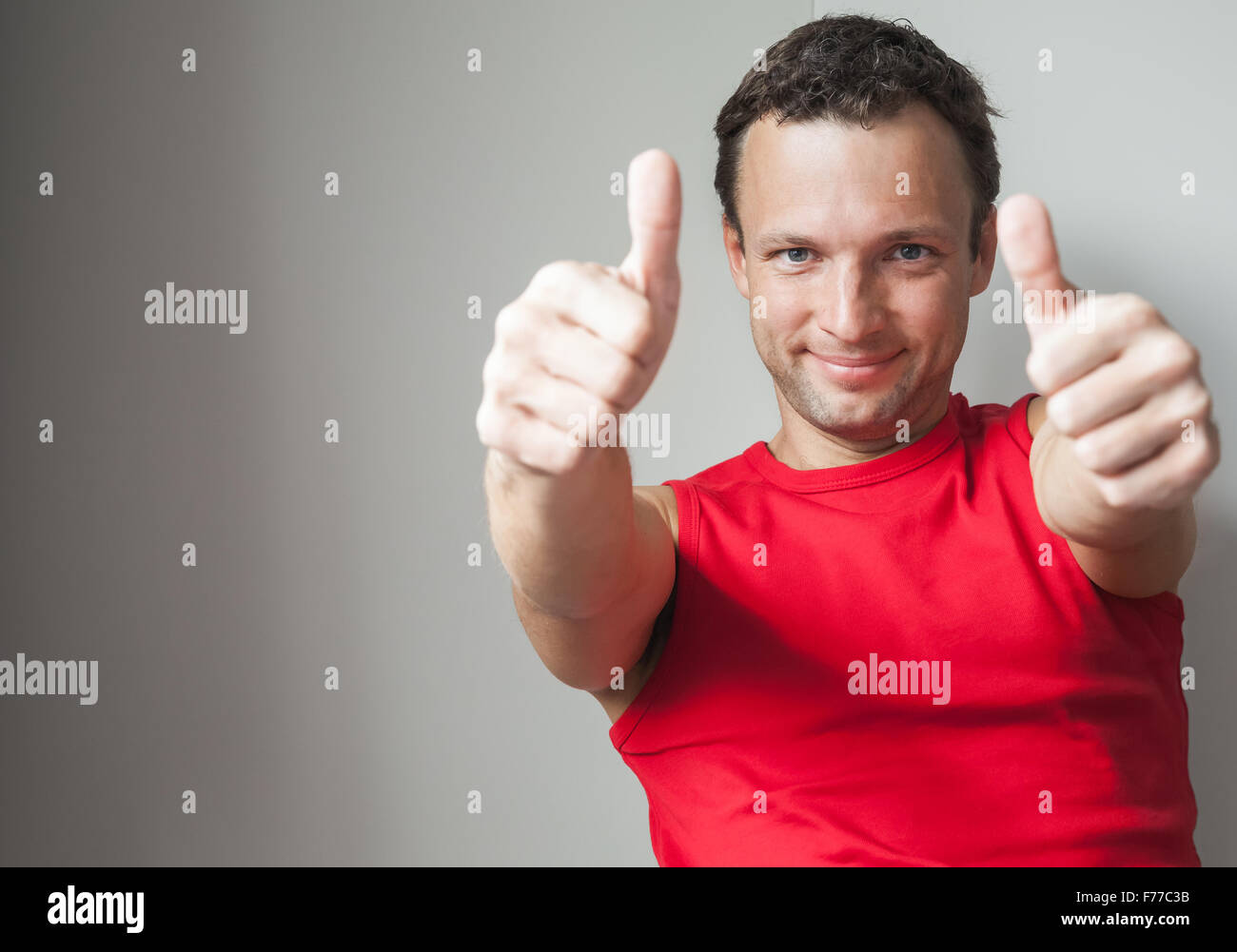 Les jeunes positifs smiling Caucasian man montre Thumbs up, studio portrait Banque D'Images