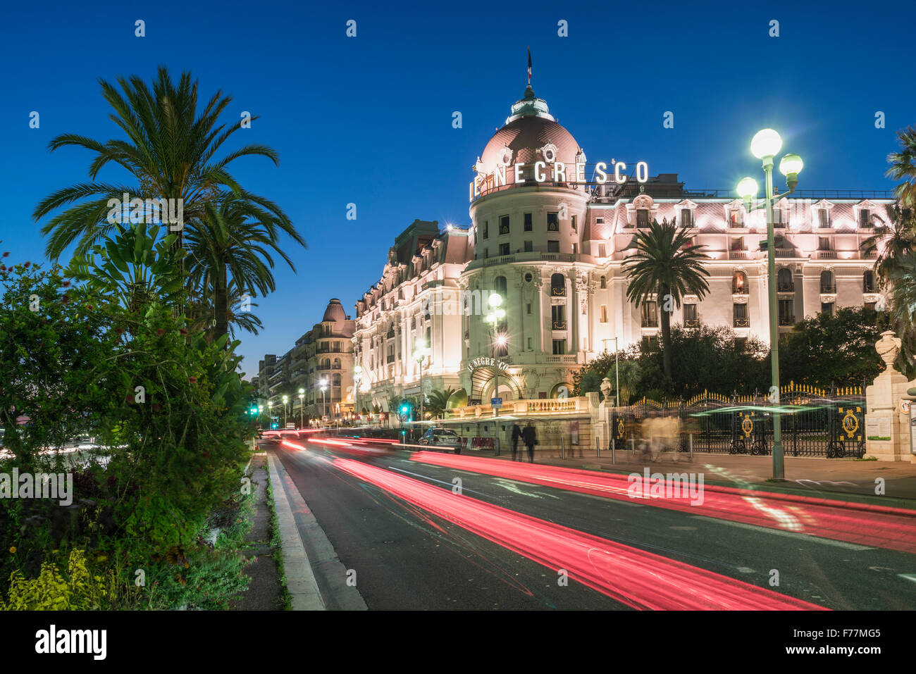 L'hôtel Negresco sur la Promenade des Anglais à Nice, de palmiers, de la circulation, crépuscule, Provence-Alpes-Côte d'Azur, France Banque D'Images