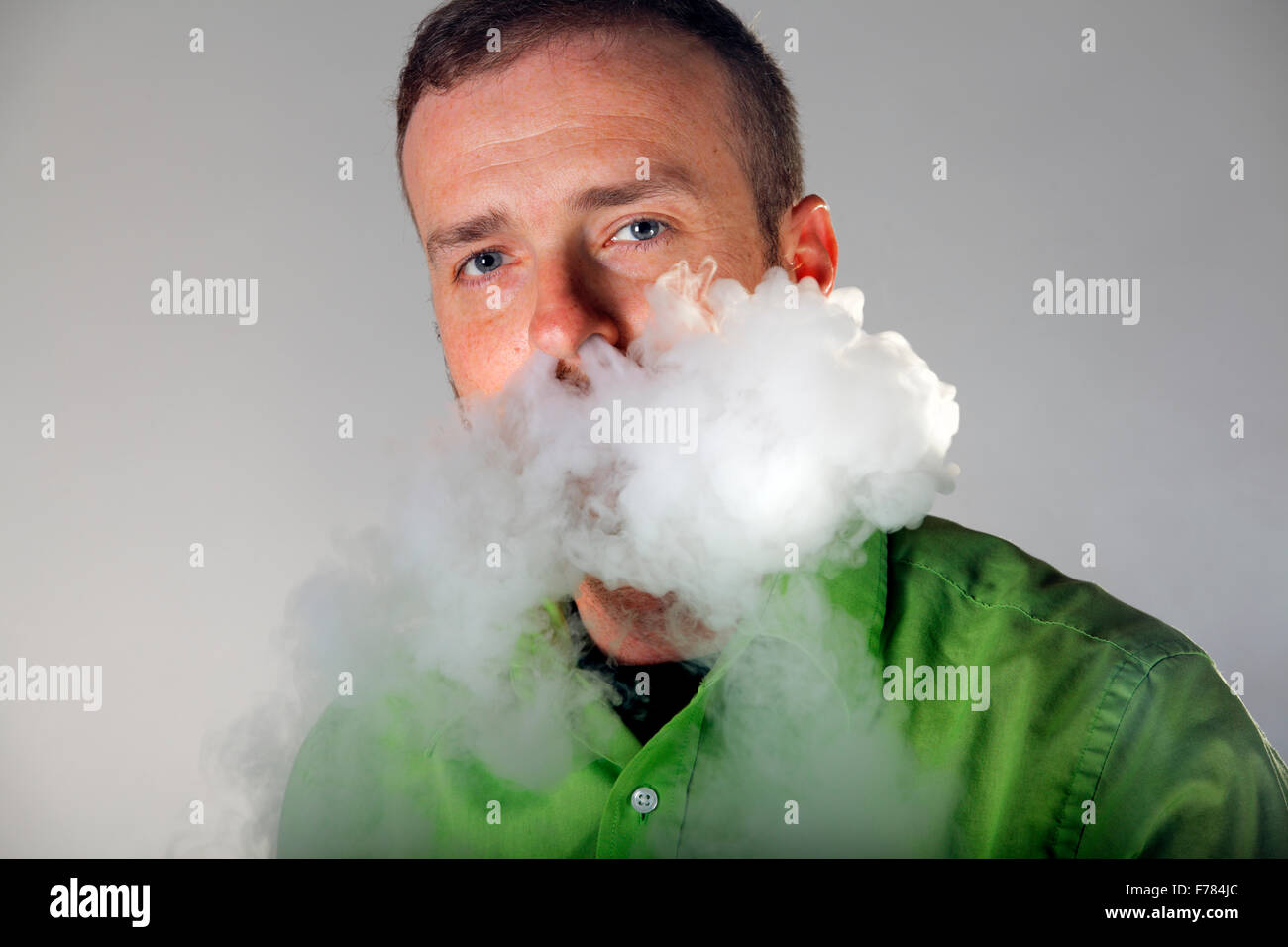 Un homme souffle de vapeur d'e-cigarette de son nez. Banque D'Images