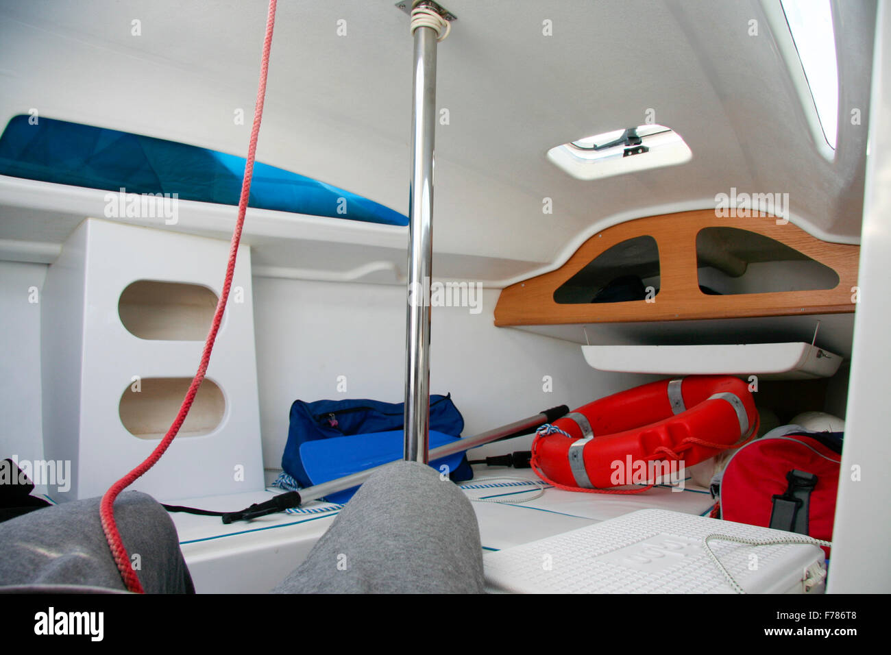 Espace de vie de petit voilier avec des rangées, gilets et autres objets nautiques Banque D'Images