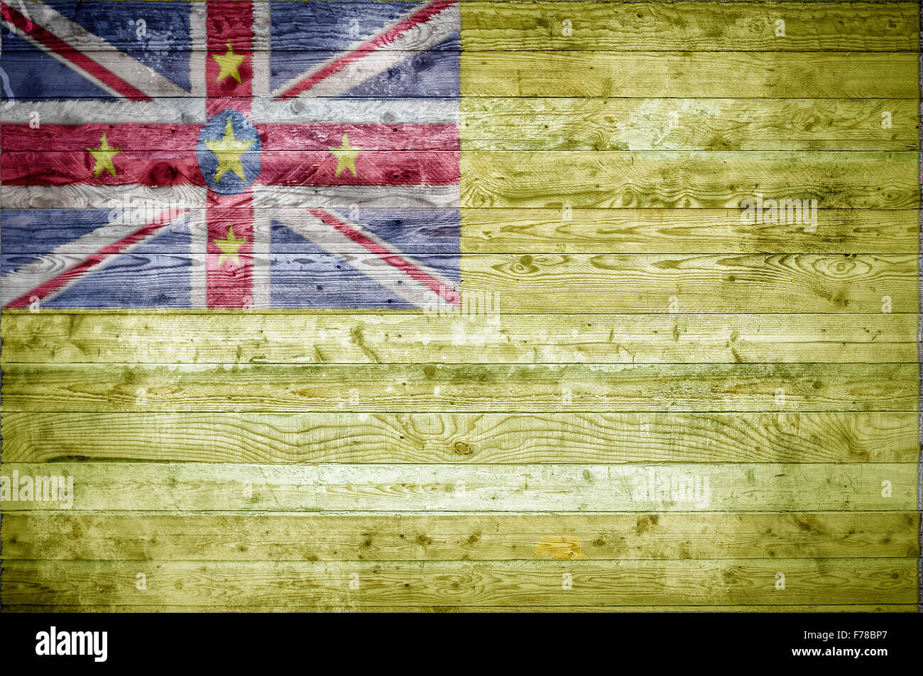 Une vignetted image de fond du drapeau de Niue sur planches de bois d'un mur ou le plancher. Banque D'Images