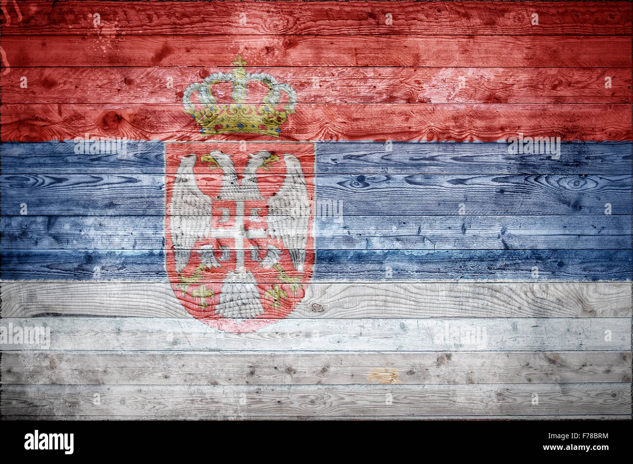 Une vignetted image de fond du drapeau de la Serbie sur les planches de bois d'un mur ou le plancher. Banque D'Images