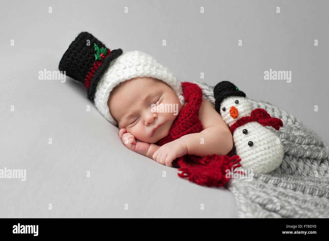 Dormir, deux semaine, nouveau-né, bébé garçon portant un bonnet et écharpe  bonhomme au crochet avec des jouets en peluche Photo Stock - Alamy