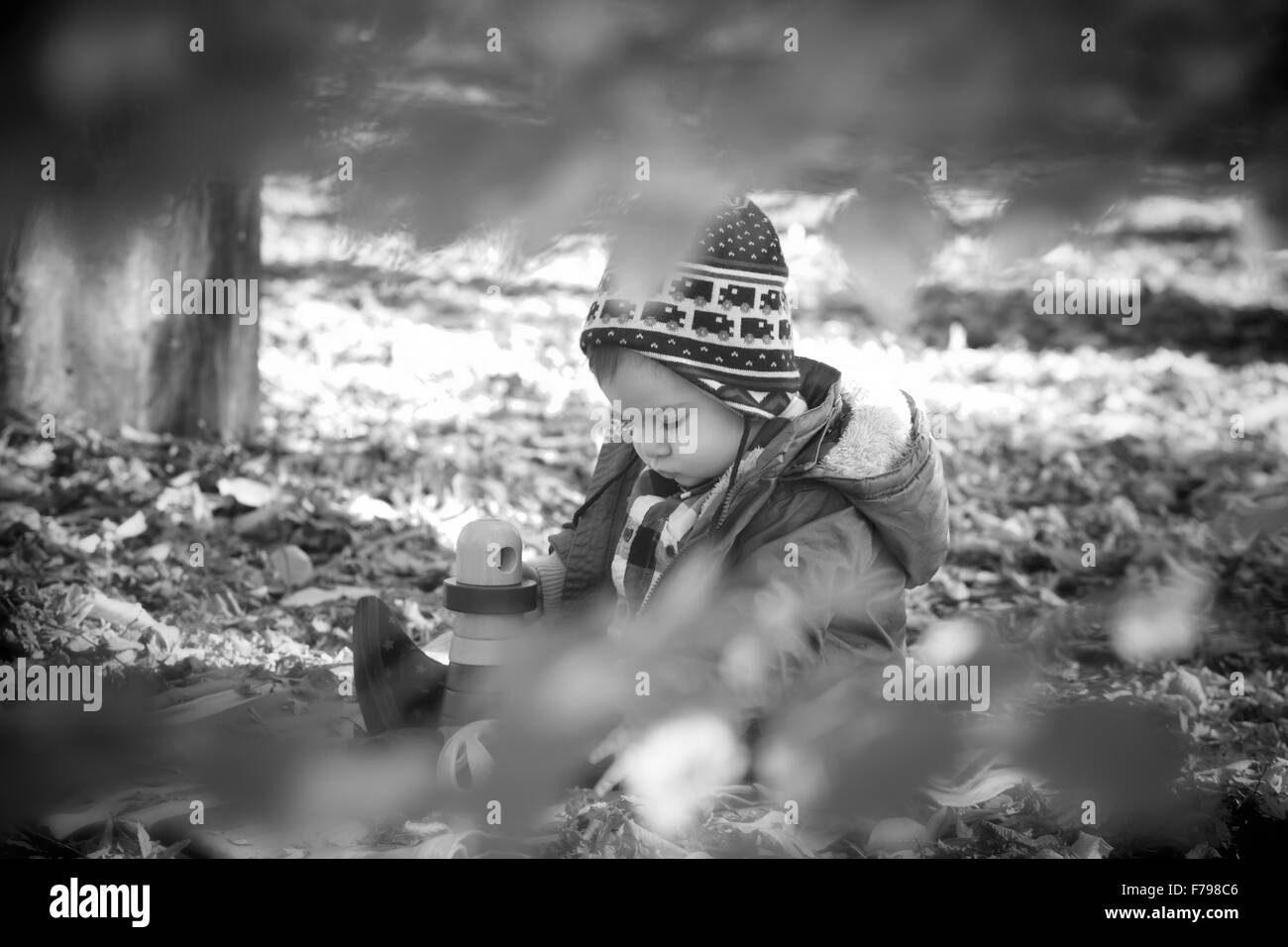 Portrait de 8 mois bébé garçon profitant d'une journée d'automne dans le parc entre les arbres et les feuilles. Banque D'Images