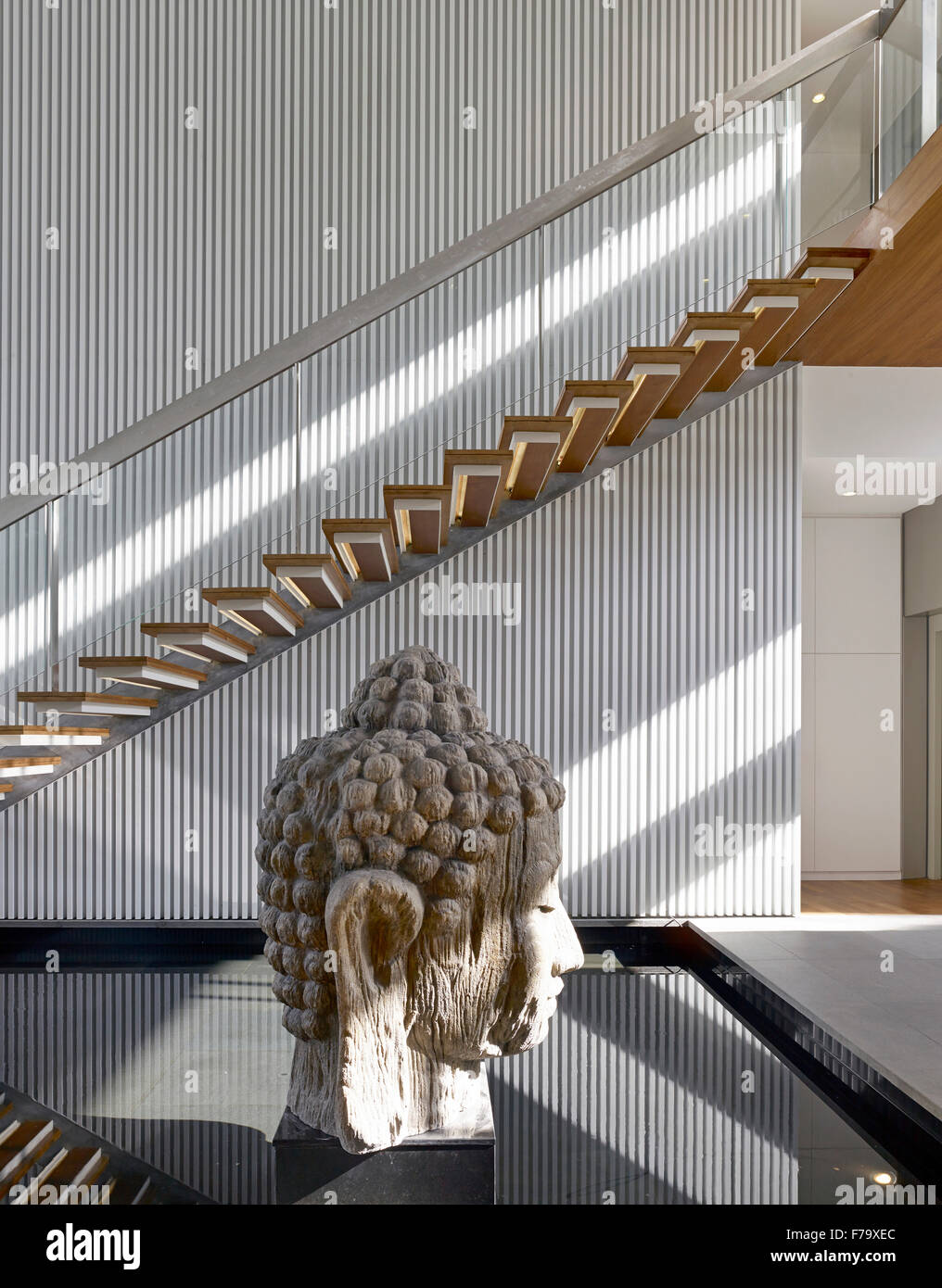 Tête de bouddha statue dans l'escalier d'une maison à Cove Way, Sentosa, Singapour conçu par Robert Greg Shand Architectes Banque D'Images