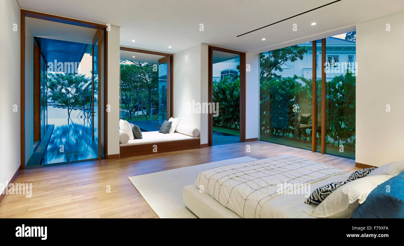 Intérieur d'une maison dans la Crique, Sentosa, Singapour conçu par Robert Greg Shand Architectes. Lit encastré dans une fenêtre donnant sur terrasse. Banque D'Images