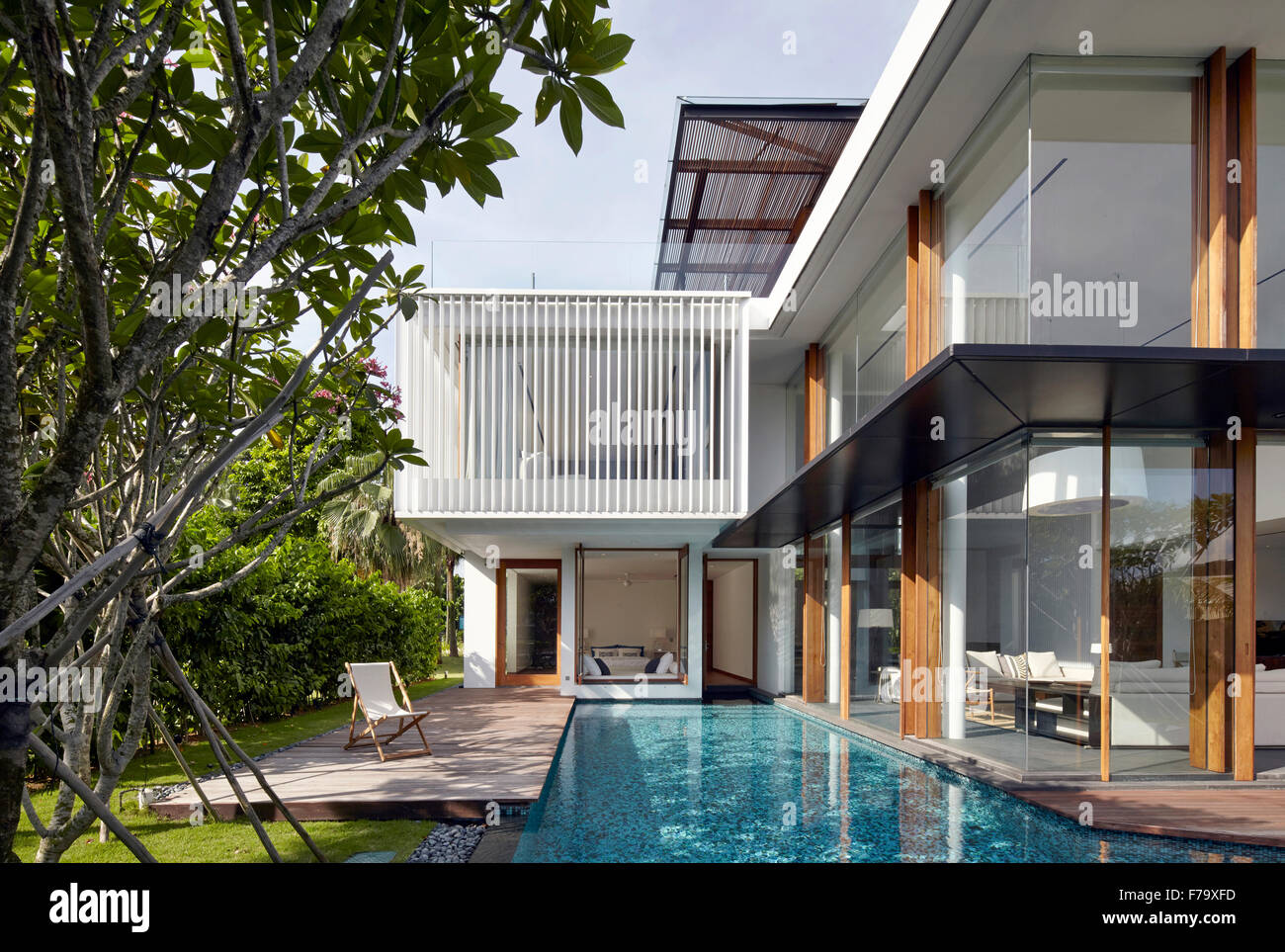 Extérieur, Piscine et terrasse avec des murs de verre d'une maison à Cove Way, Sentosa, Singapour conçu par Robert Greg Shand Architectes Banque D'Images