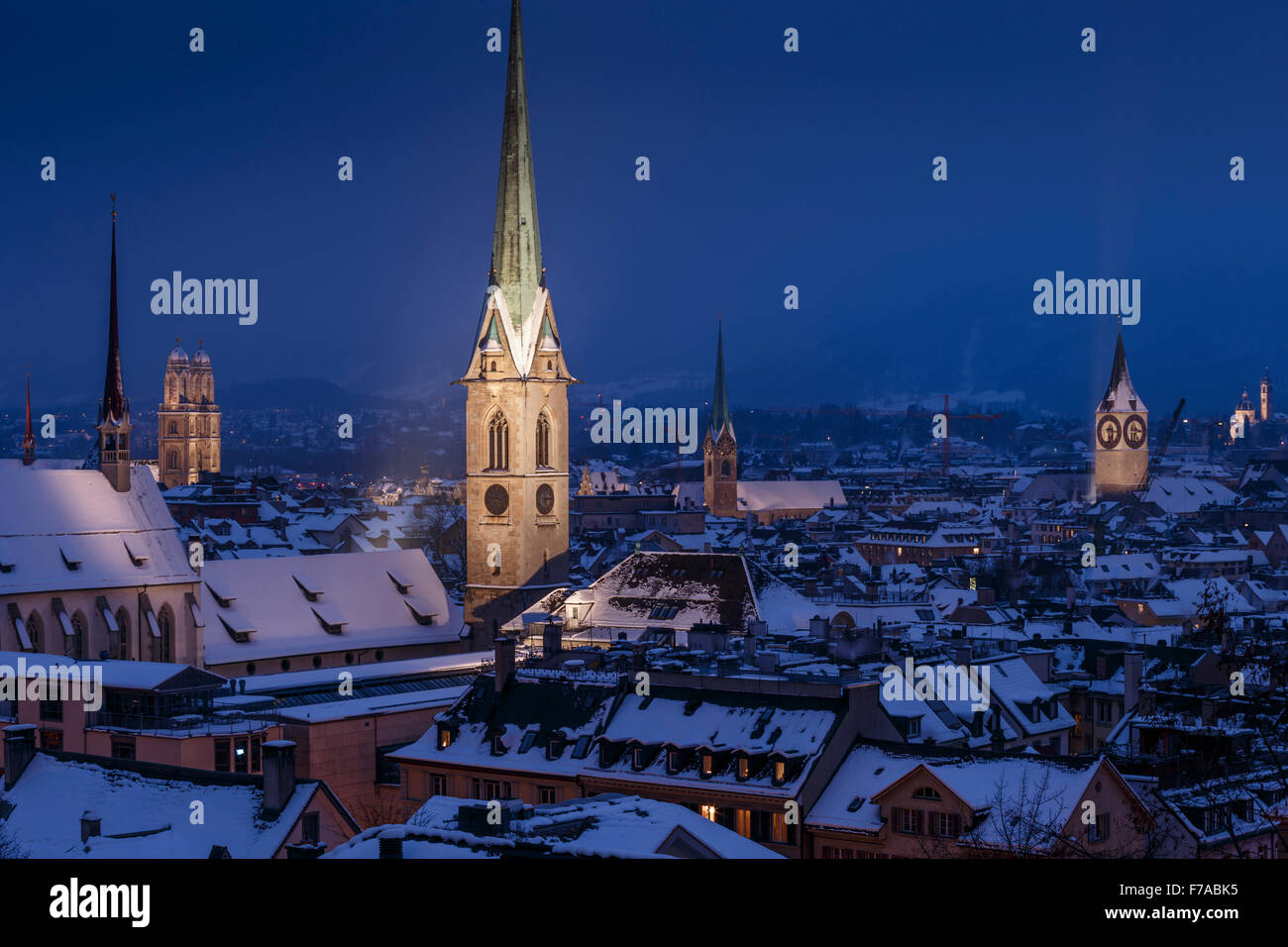 La vieille ville avec des toits couverts de neige pendant la nuit, avec le clocher gothique lumineux tours, Zurich, Suisse. Banque D'Images