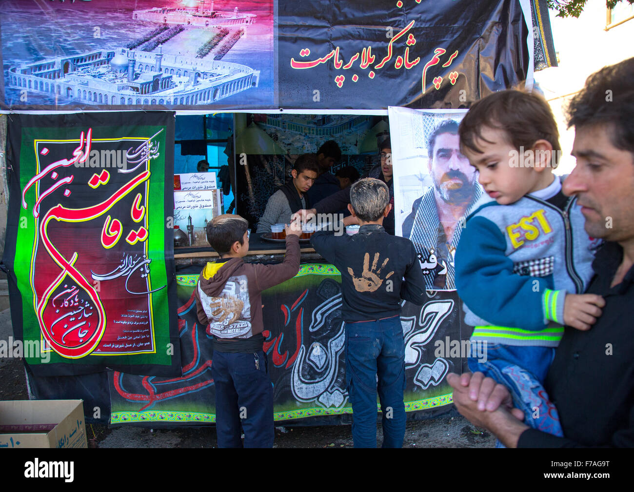 Les musulmans chiites iraniens enfants consommant de l'Nazri Plateau distribué librement au cours de Muharram, province du Kurdistan, Bijar, Iran Banque D'Images