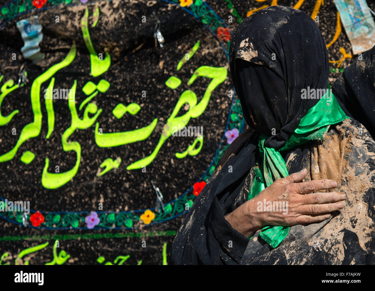 Femme musulmane chiite iranien couvert de boue avec sa main sur son coeur pendant Ashoura, le jour de la mort de l'Imam Hussein, province du Kurdistan, Bijar, Iran Banque D'Images