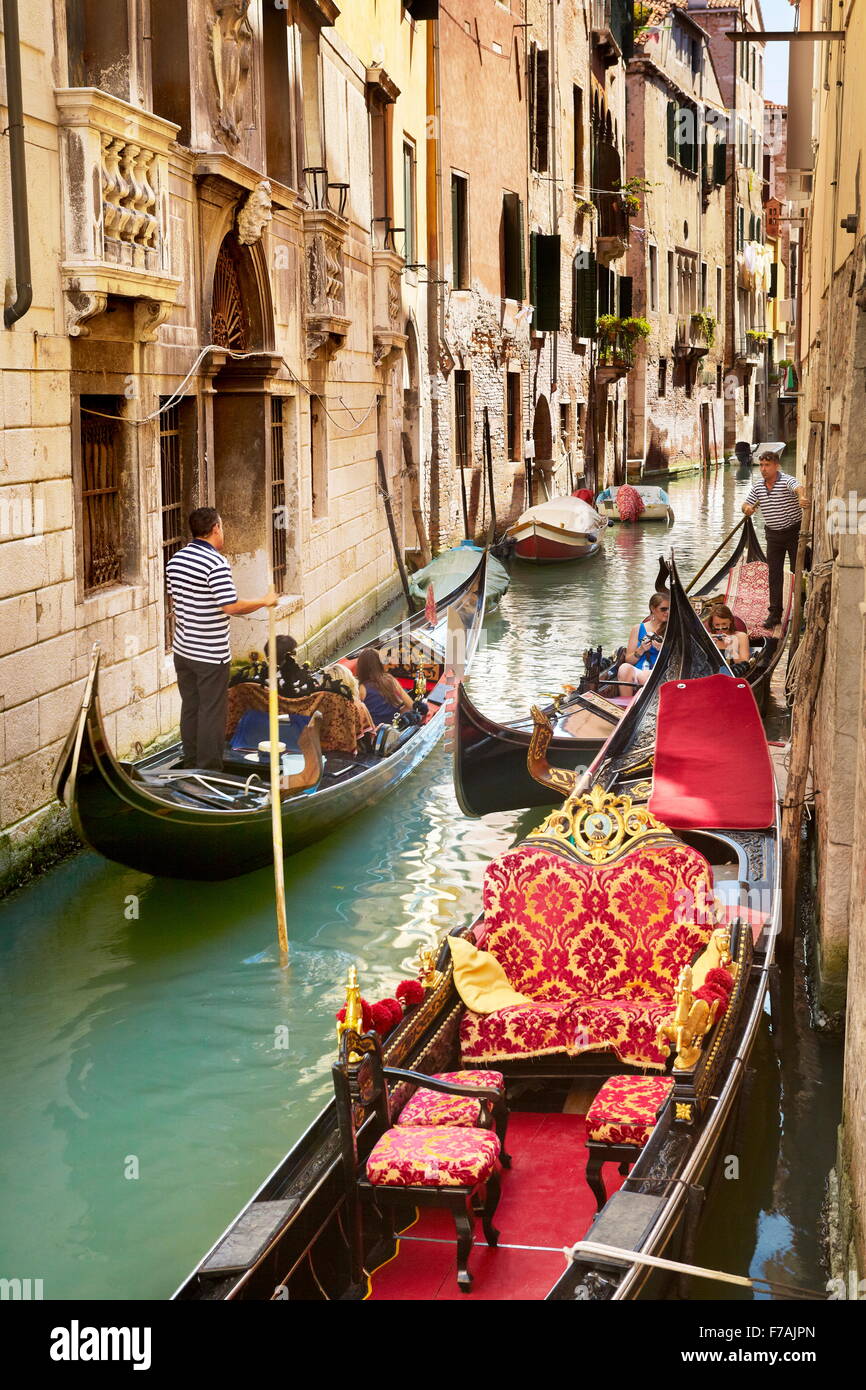 Gondolier avec sa cabine dans l'un des nombreux canaux de Venise, Vénétie, Italie, l'UNESCO Banque D'Images