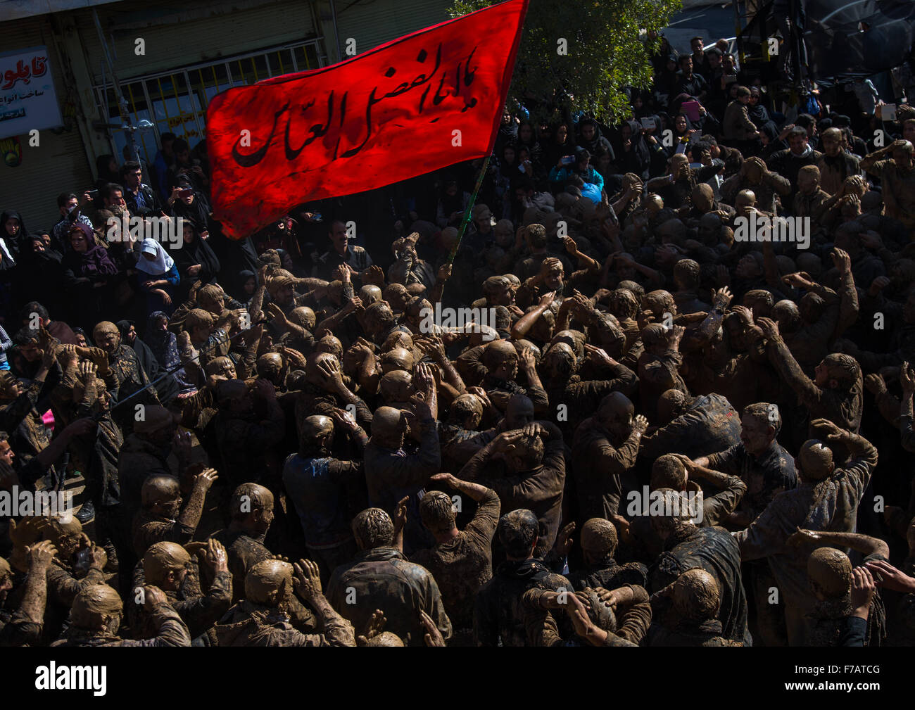Les hommes musulmans chiites iraniens couvert de boue, le chant et l'auto-flagellating pendant l'Achoura, le jour de la mort de l'Imam Hussein, province du Kurdistan, Bijar, Iran Banque D'Images