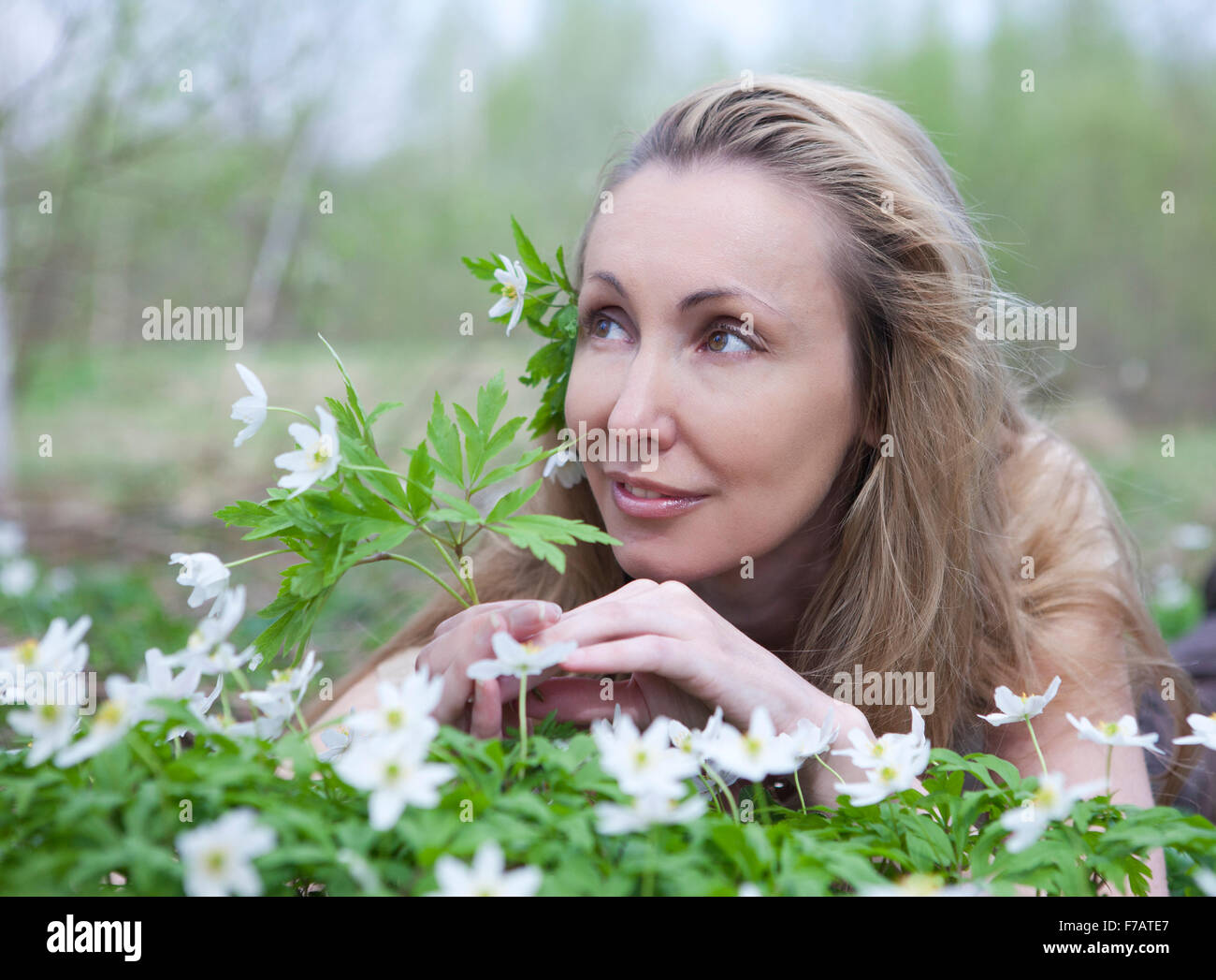 La belle jeune femme sur une clairière de perce-neige en fleurs Banque D'Images