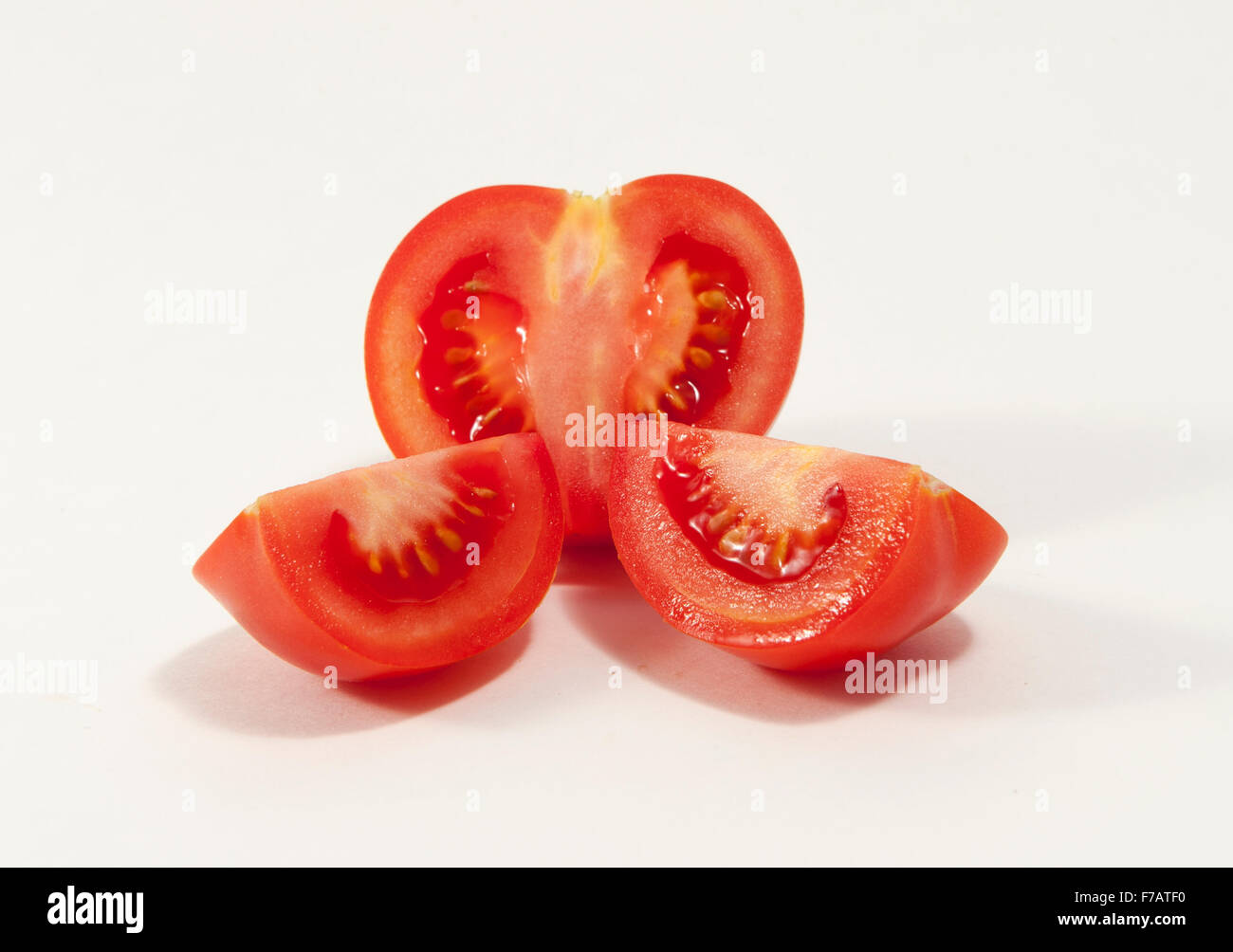 La Tomate et deux quarts sur un fond blanc. Banque D'Images