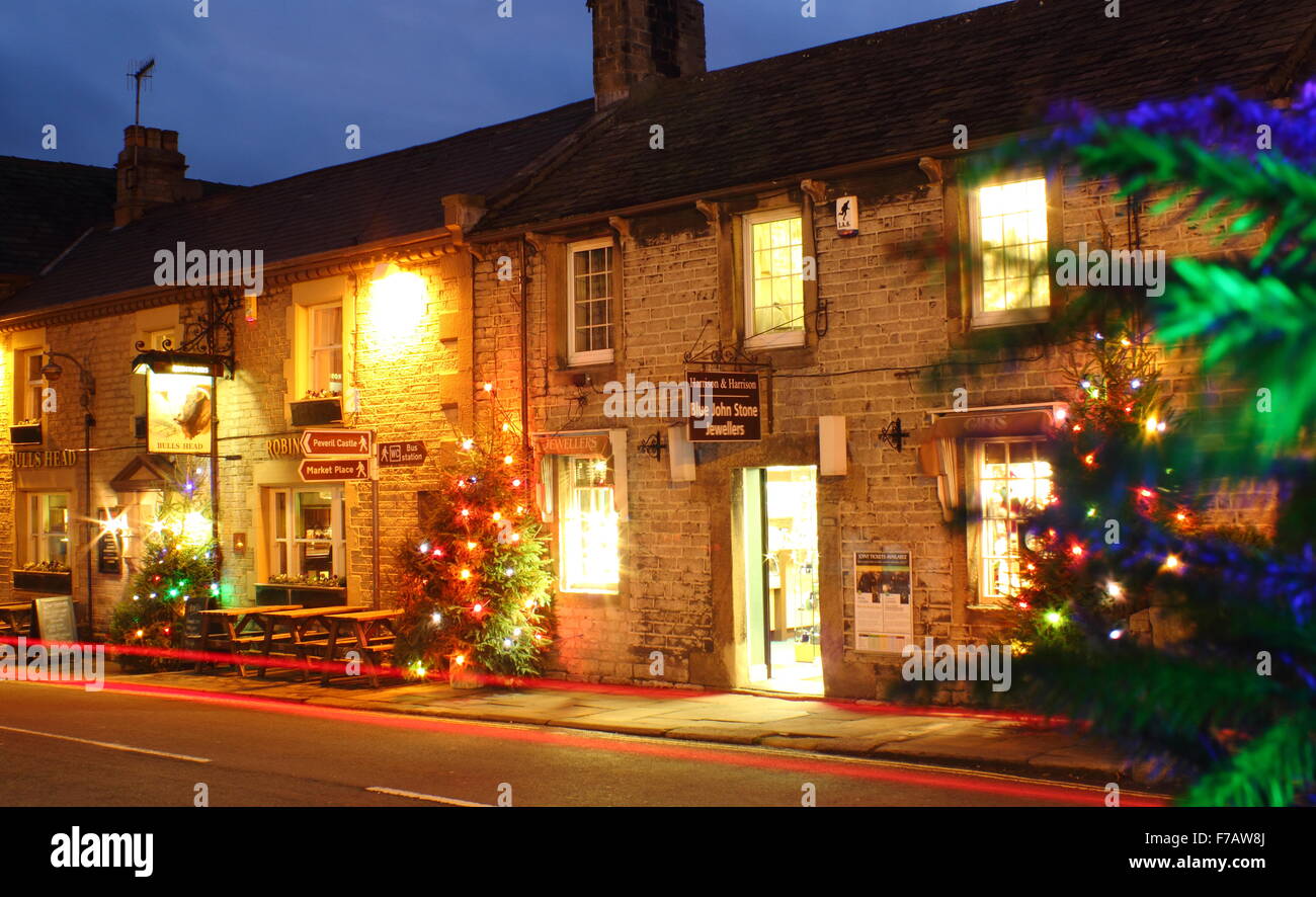 Les arbres de Noël décorés illuminent la rue principale en Castleton ; un village traditionnel dans le Peak District, Derbyshire, Angleterre Banque D'Images