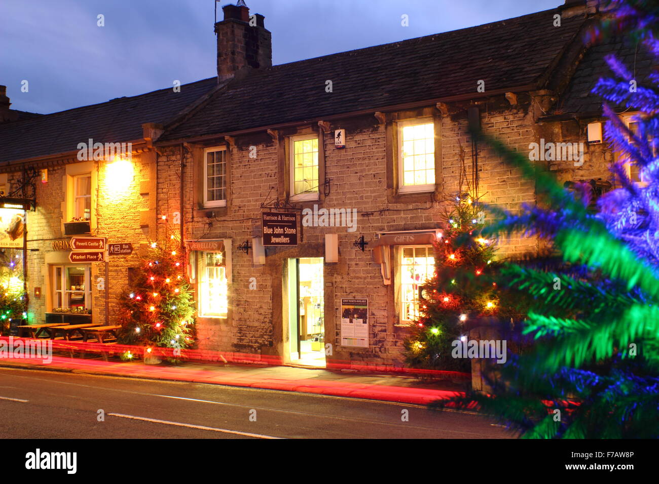 Les arbres de Noël décorés illuminent la rue principale en Castleton ; un village traditionnel dans le Peak District, Derbyshire, Angleterre Banque D'Images