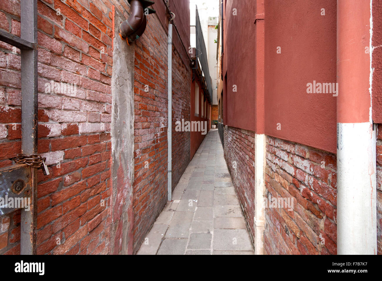 Une ruelle étroite avec des murs en brique et la douleur rose Banque D'Images