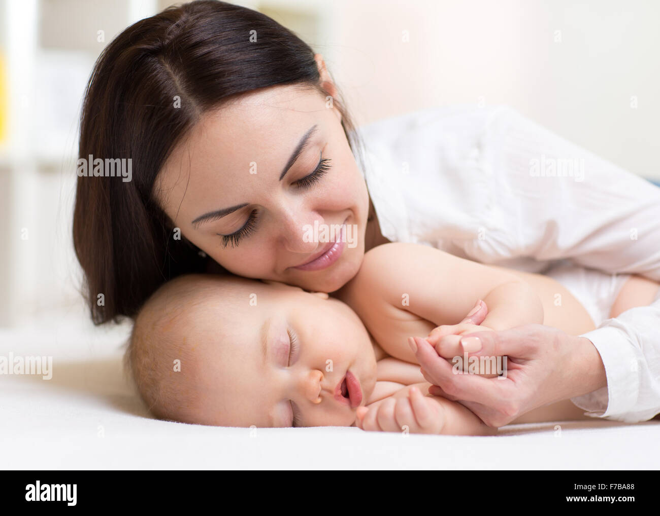 Jeune maman heureuse près de sleeping baby Banque D'Images