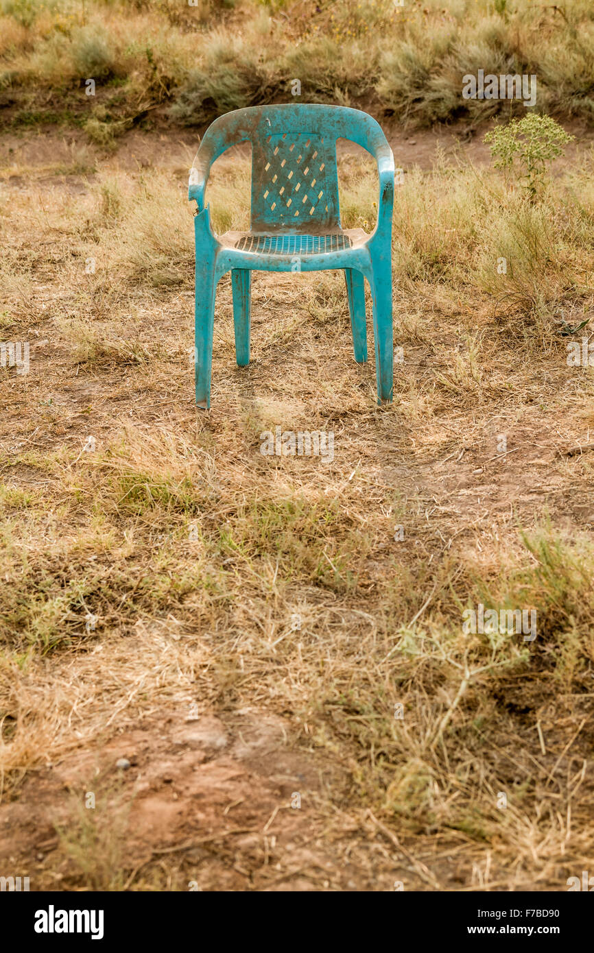 Retro grunge fauteuil vert plastique endommagés et abandonnés dans un champ Banque D'Images