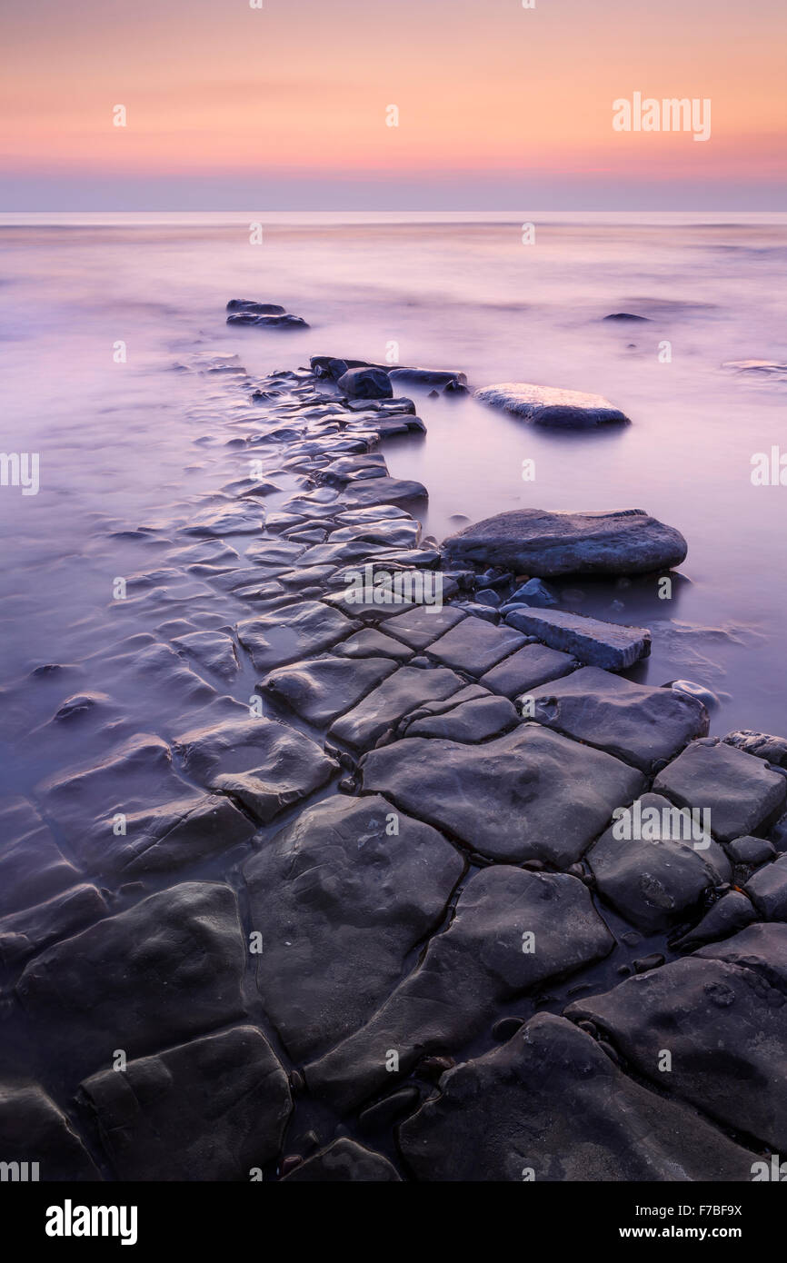 De belles formations rocheuses du plomb dans la mer au coucher du soleil à Southerndown, Vale of Glamorgan, Pays de Galles Banque D'Images