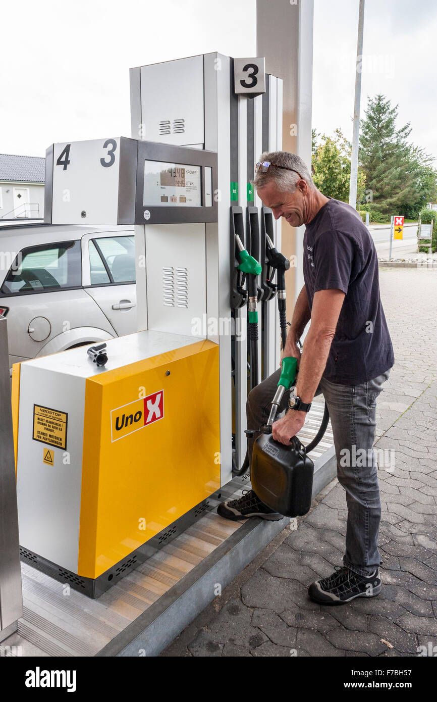 L'homme de remplir le réservoir de carburant à la pompe à essence peut dans la station de remplissage, le Danemark, l'Europe. Banque D'Images