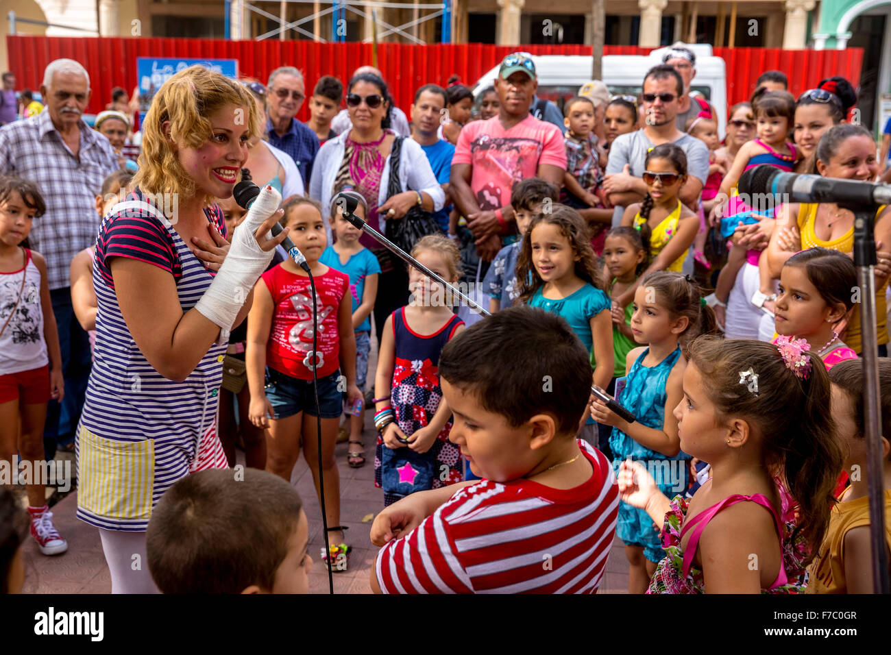 Une jeune fille avec un microphone à l'clown et bénéficie d''enfants, Streetlife dans le centre de Santa Clara à Parque de Santa Cla Banque D'Images