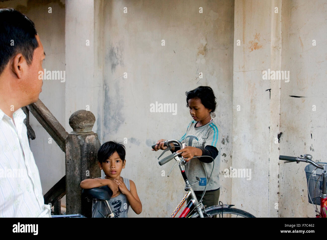 Un garçon de 11 ans regarde loin comme sa sœur, âgée de 14 ans, s'apprête à chercher un emploi dans un bidonville à Kampong Cham, Cambodge. Banque D'Images