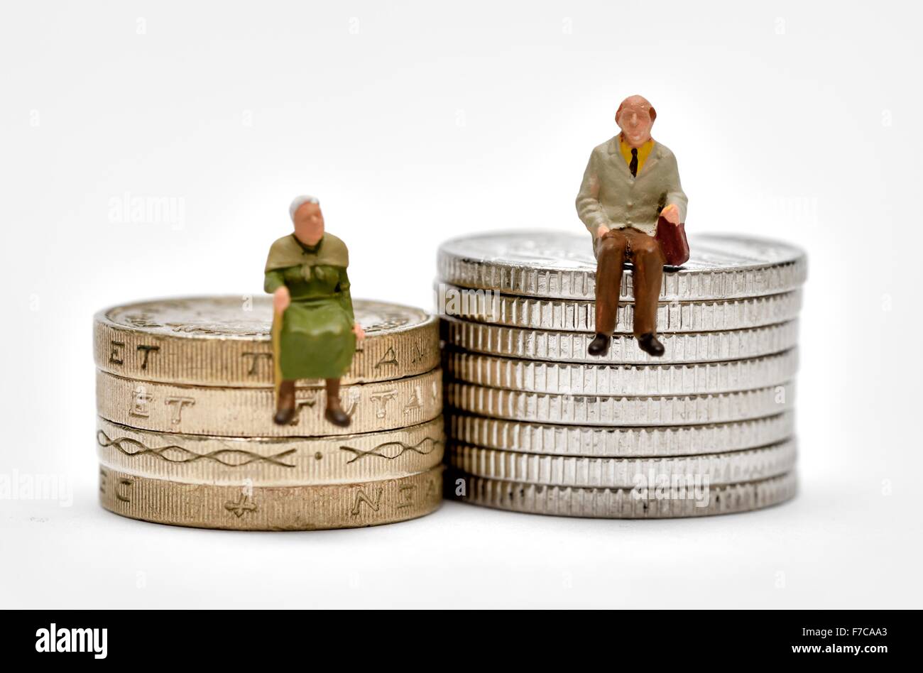 Des gens assis sur miniatures pièces livre et 10 pence morceaux Banque D'Images