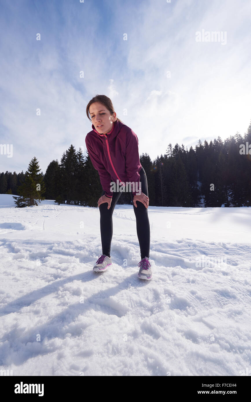 Yougn woman jogging en plein air, sur la neige en forêt, l'hiver et des loisirs sains de style de vie Banque D'Images