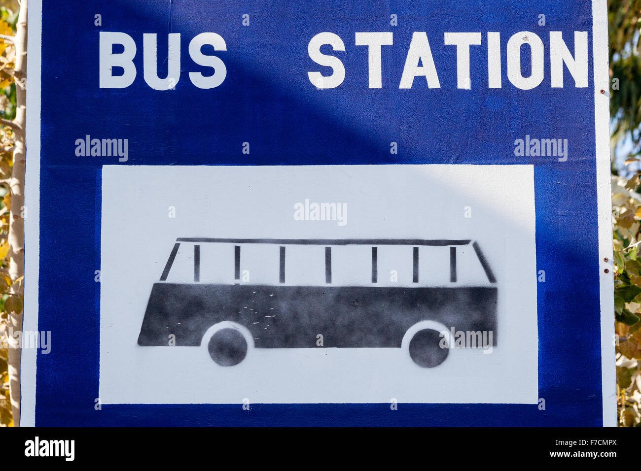 Santorin, Théra. Signe de la gare routière. Découpe de noir sur fond blanc bus carré encadré de bleu de la station de bus surround avec '' en lettres blanches. Banque D'Images