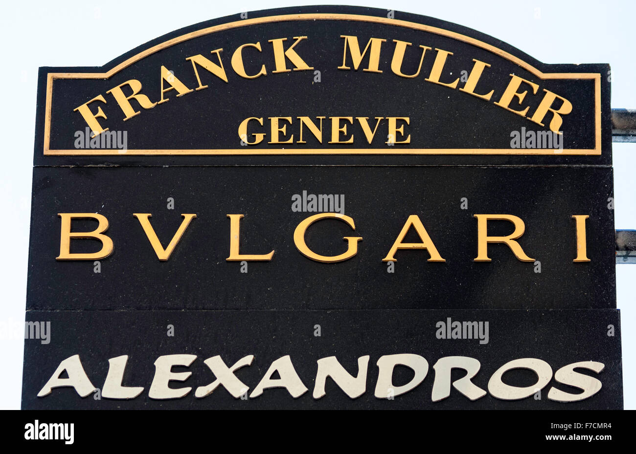 Hanging boutique sign, brun foncé signe avec la couleur d'or des lettres, les noms de marque, Franck Muller, Geneve et Bvlgari. Banque D'Images
