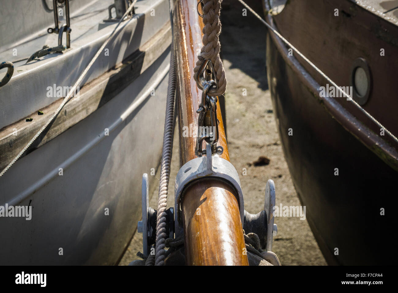 Chantier naval avec vue partielle de mât en bois et les coques de deux bateaux. Banque D'Images