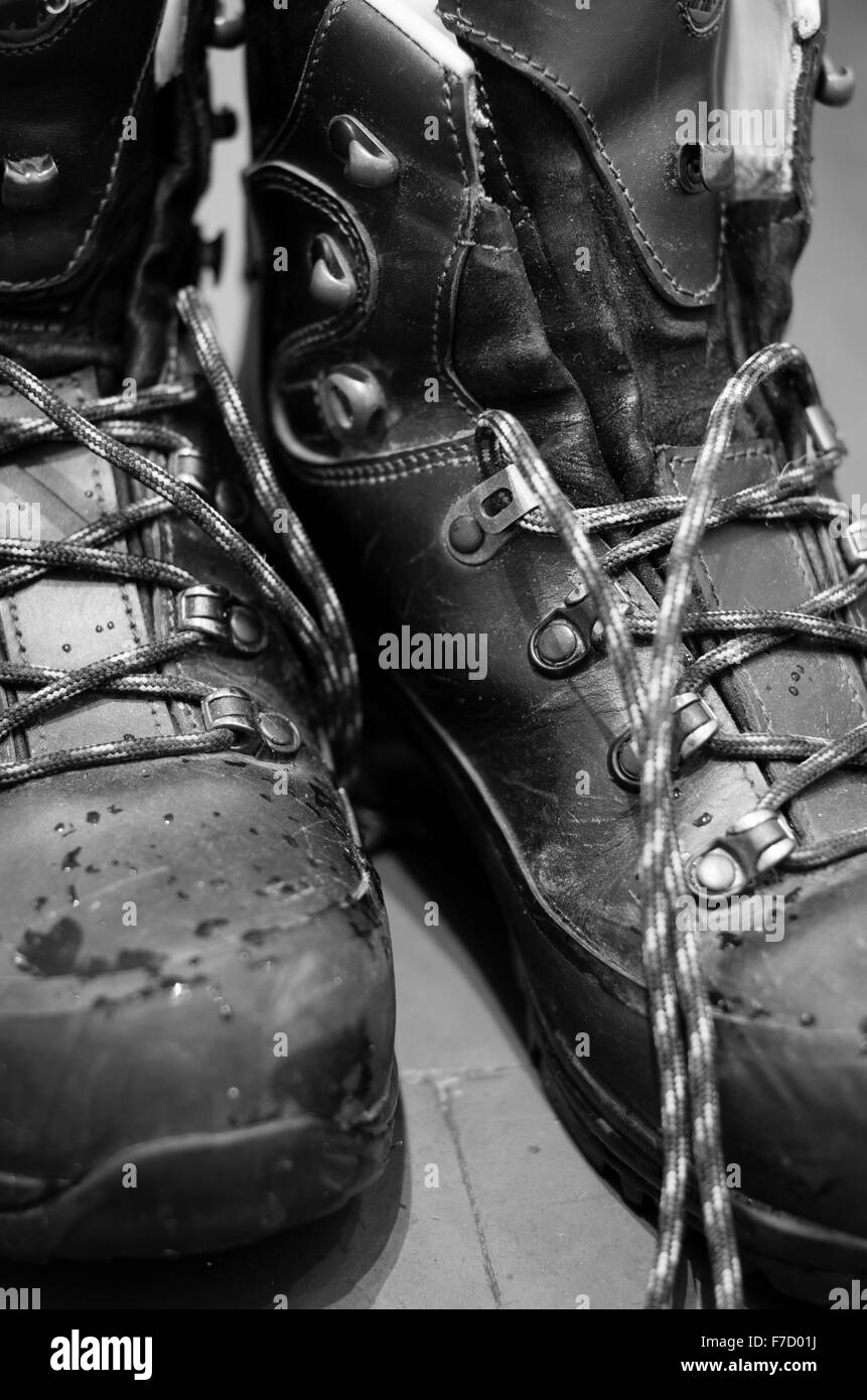 Paire de bottes de randonnée en cuir humide unlaced sur carrelage carrière Banque D'Images