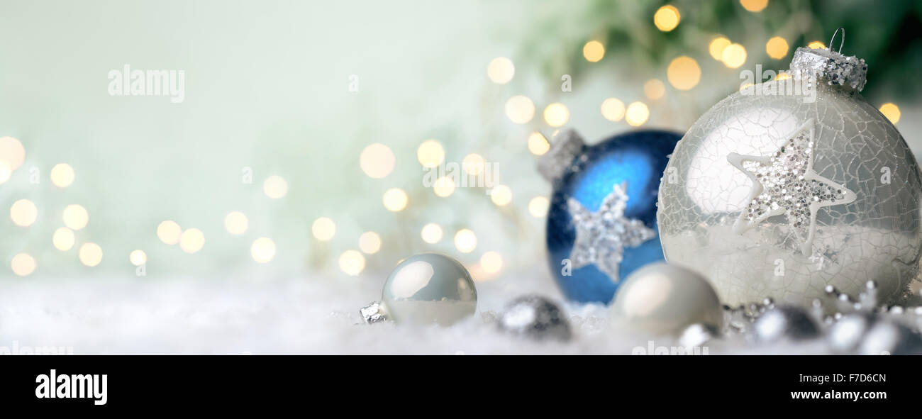 Noël arrière-plan panoramique avec de belles boules luisantes sur la neige et les lumières de flou artistique en arrière-plan, avec du vert spa copie Banque D'Images