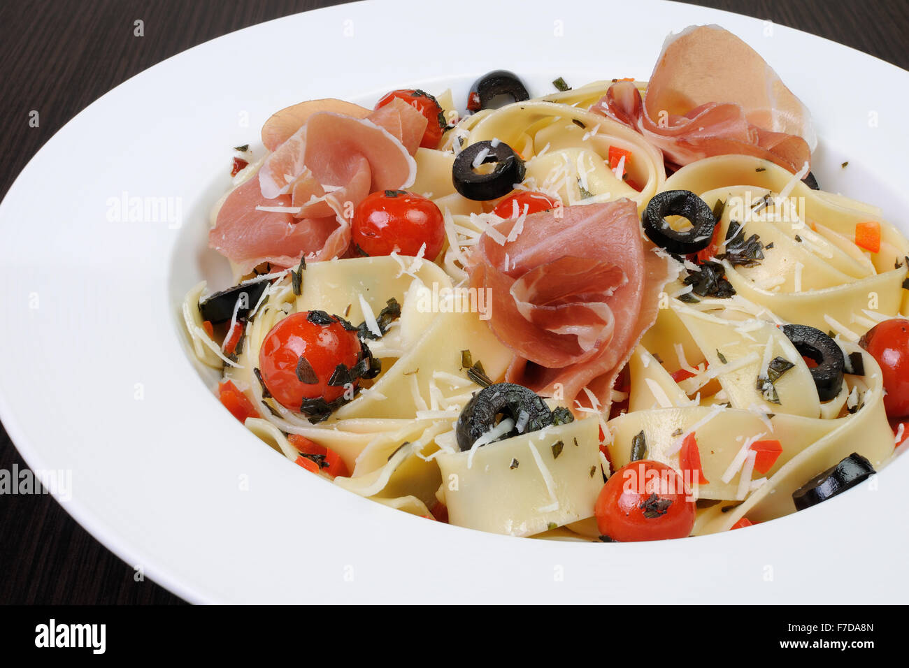 Assiette de spaghetti au jambon, tomates, olives et parmesan Banque D'Images